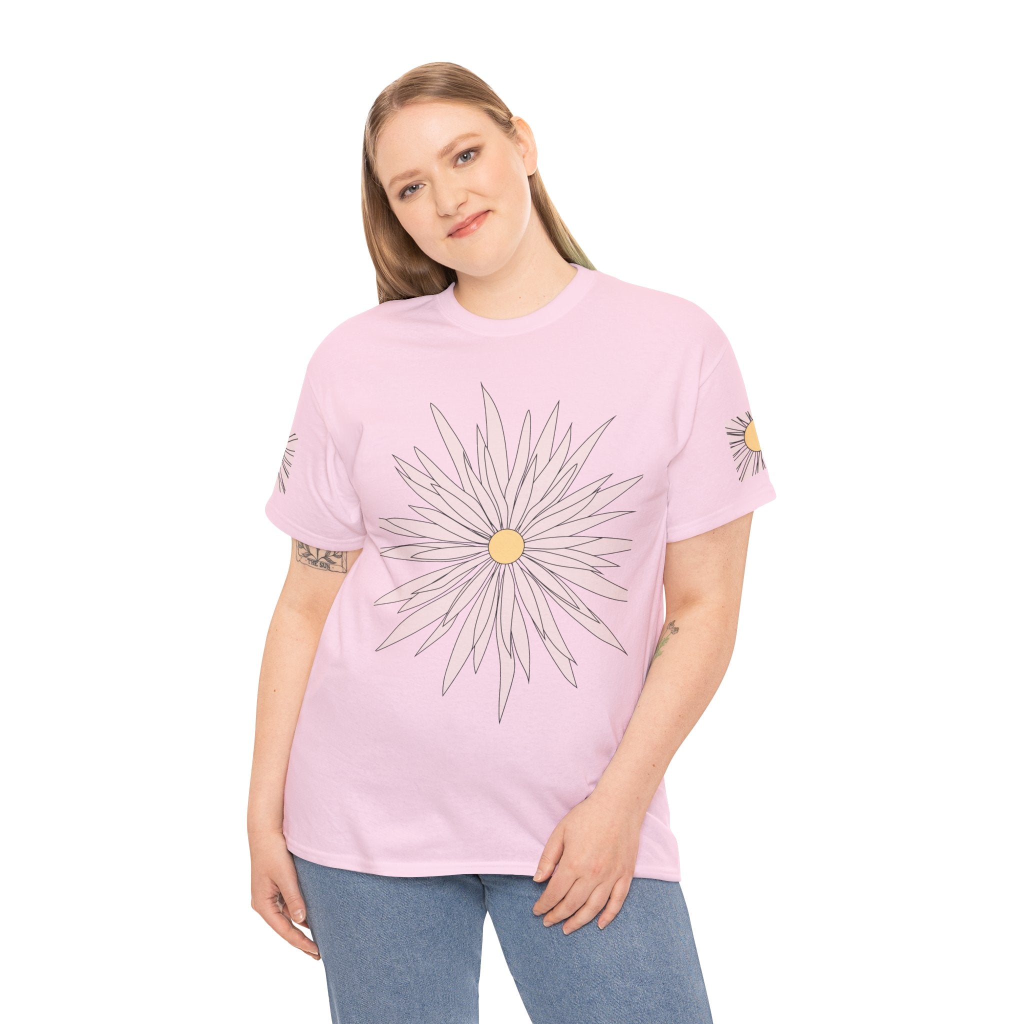 Light pink graphic tee on model with large daisy flower print on front and small sleeve details.