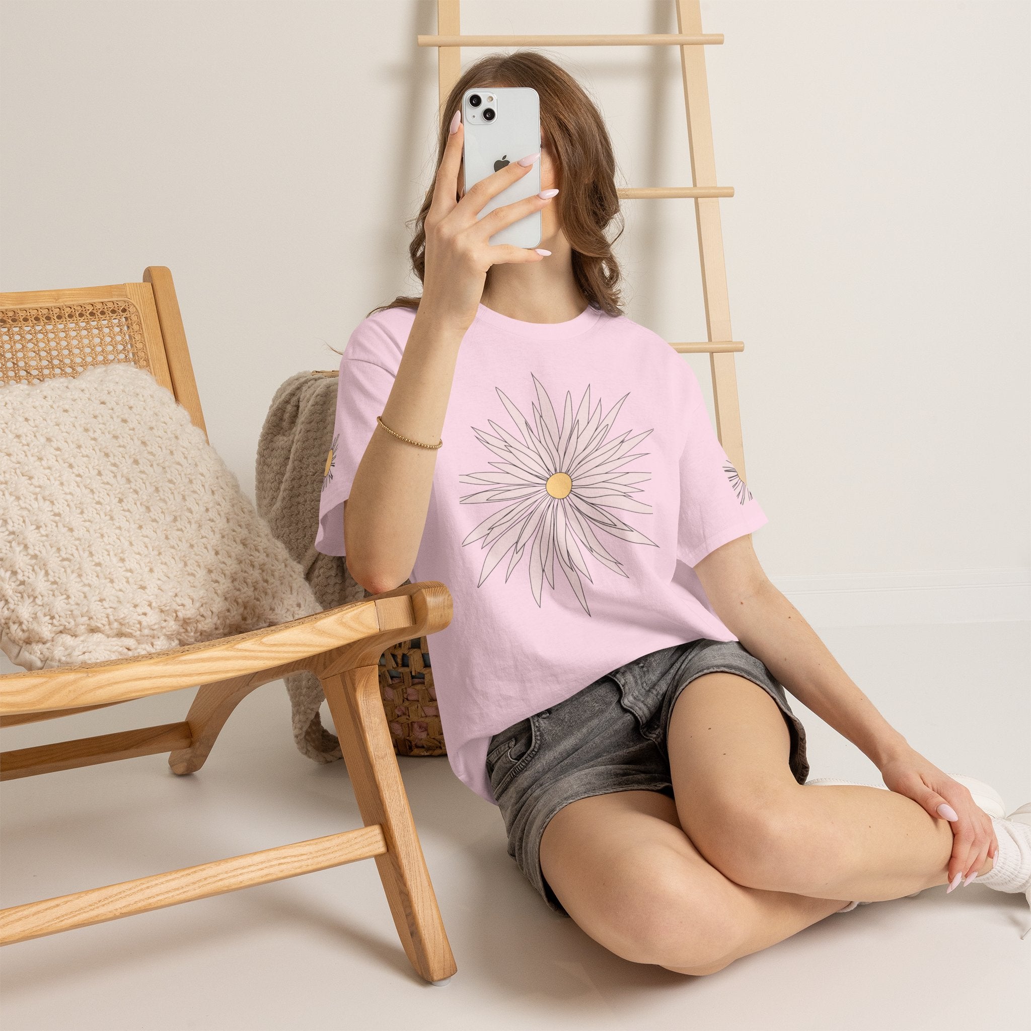 Light pink graphic tee worn with large daisy flower front print and small sleeve daisy details.