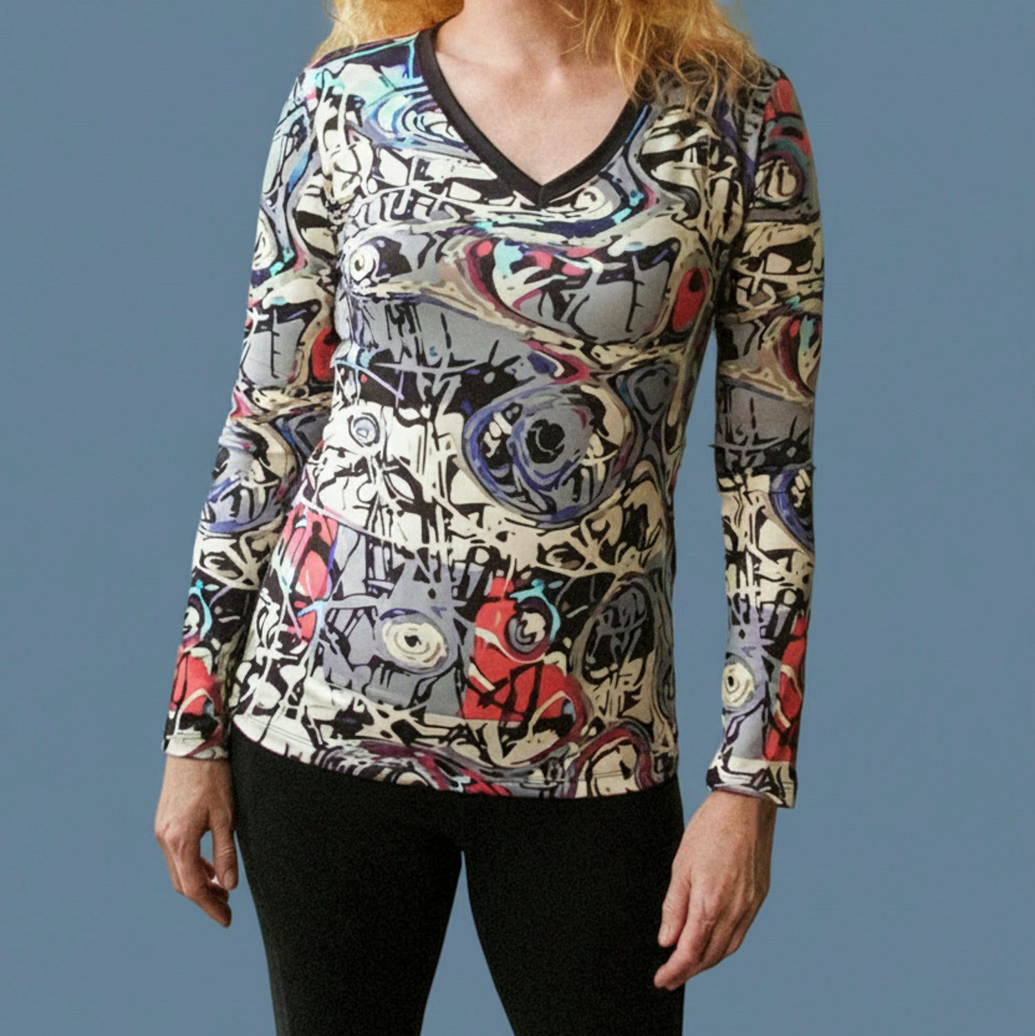 Graffiti V-neck long-sleeve shirt on model, multicolor abstract print over black V-neck trim