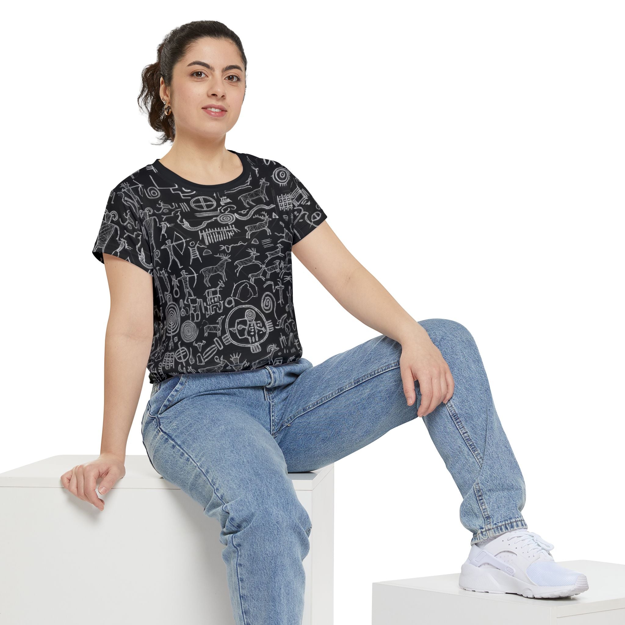 Women’s black short-sleeve tee with chalk petroglyph pattern worn with jeans